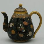 Cloisonne teapot decorated with flowers and butterflies on a black background Made by Namikawa Yasuyuki in Japan, c1890.