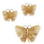 A diamond and ruby butterfly brooch and ear clip set